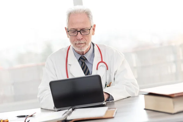 Medico anziano che utilizza laptop — Foto Stock