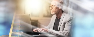 Dizüstü bilgisayar kullanan olgun işadamı; çoklu pozlama