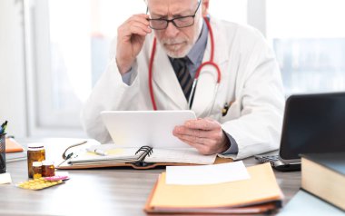Dijital tablet kullanan erkek kıdemli doktor