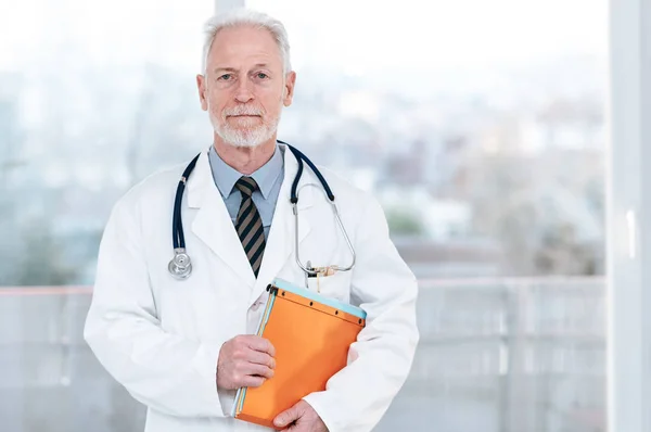 Retrato del médico de pie y sosteniendo una carpeta —  Fotos de Stock