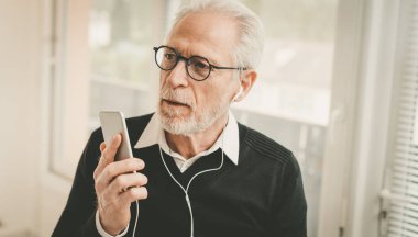 Cep telefonuyla sohbet sırasında kulaklık kullanan işadamı