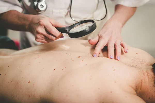 Dermatolog zkoumat kůži pacienta — Stock fotografie