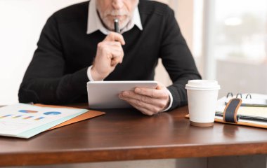 Ofiste dijital tablet üzerinde çalışan bir işadamı