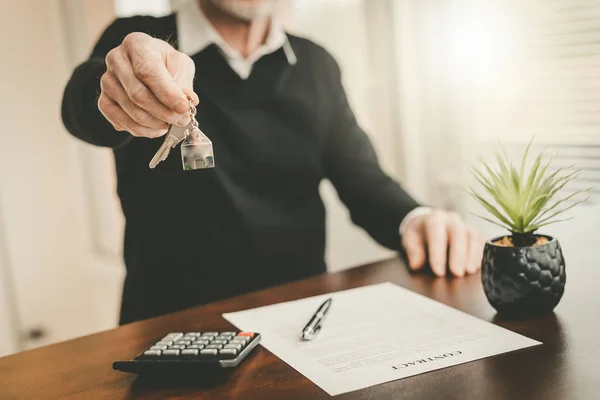 Real estate agent showing house keys — Stock Photo, Image