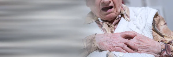Mujer mayor que sufre de un ataque al corazón; bandera panorámica — Foto de Stock
