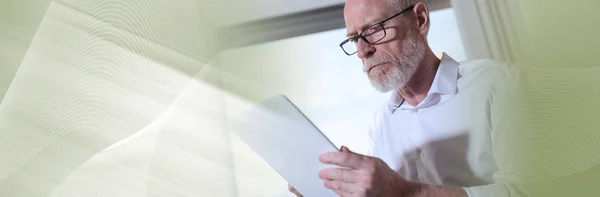 Hombre de negocios senior usando una tableta digital, luz dura. panorámica —  Fotos de Stock