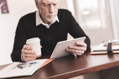 Ofiste dijital tablet üzerinde çalışan bir işadamı