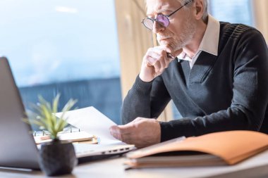 Kıdemli işadamı bir belge okuyor