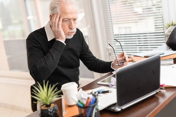 Überlasteter Geschäftsmann sitzt an unordentlichem Schreibtisch — Stockfoto