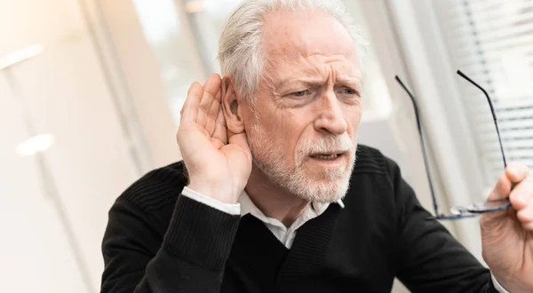 Senior mann med hørselsproblemer – stockfoto