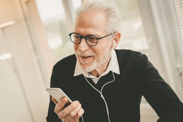Affärsman som använder hörlurar under samtal på mobiltelefon — Stockfoto