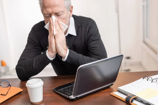 Hombre de negocios mayor sonándose la nariz — Foto de Stock