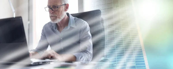 Portret van senior zakenman die op laptop, lichteffect werkt; — Stockfoto