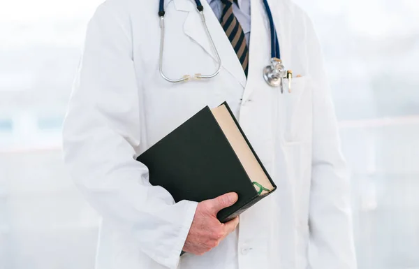 Doctor holding a medical textbook — Stock Photo, Image