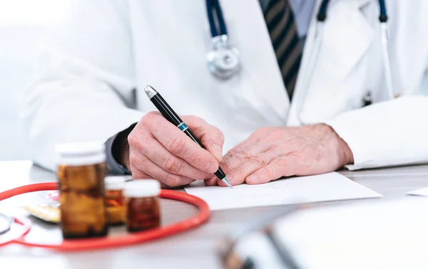 Médico escribiendo una receta médica — Foto de Stock