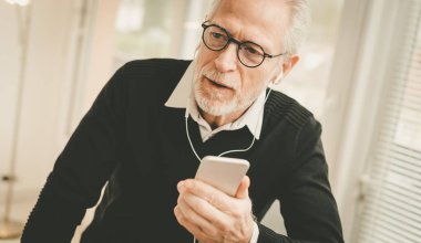 Cep telefonuyla sohbet sırasında kulaklık kullanan işadamı