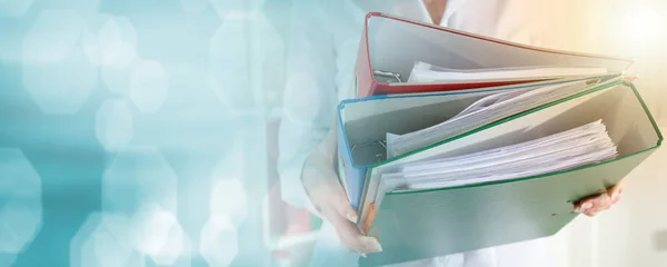 Businesswoman holding binders; light effect — Stock Photo, Image