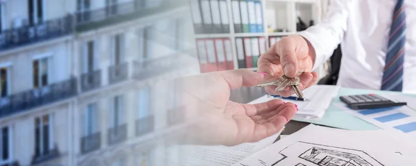 Vastgoedmakelaar die sleutels aan zijn klant geeft; meervoudige belichting — Stockfoto