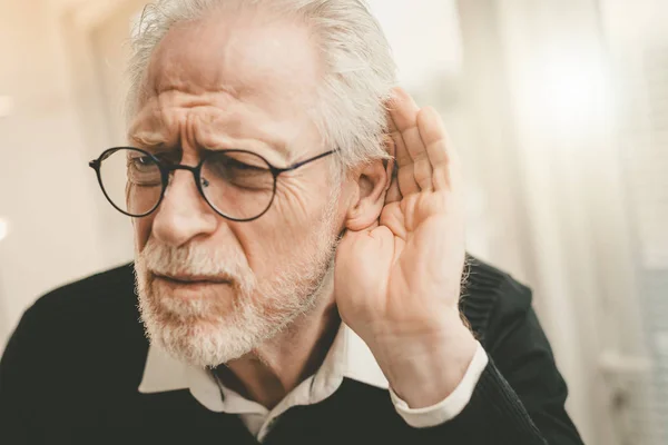 Hombre mayor con problemas auditivos — Foto de Stock