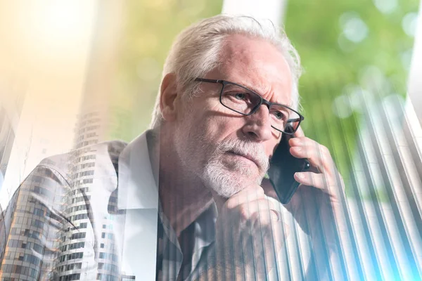 Starszy biznesmen rozmawia na telefon komórkowy; wielokrotne narażenie — Zdjęcie stockowe
