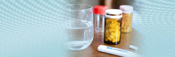 Drugs, glass of water and medical thermometer on a nightstand; p — Stock Photo, Image