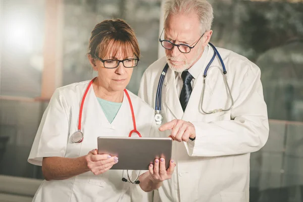 Dois médicos discutindo sobre o relatório médico no tablet — Fotografia de Stock