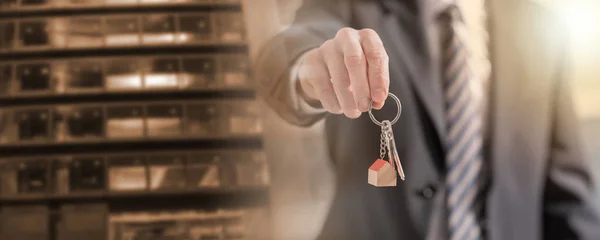 Immobilienmakler bietet Hausschlüssel an; Mehrfachbelichtung — Stockfoto