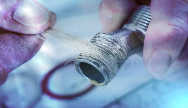 Plumber putting hemp fibers on a thread, light effect — Stock Photo, Image