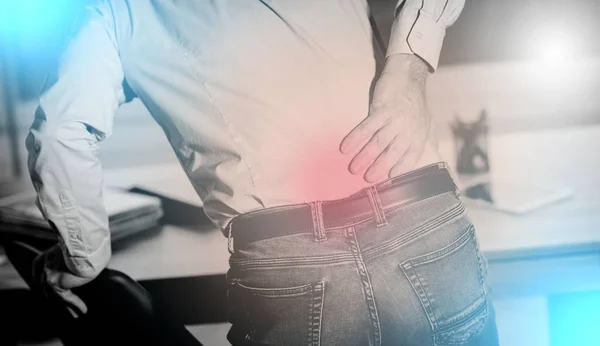 Businessman suffering from back pain, light effect — Stock Photo, Image