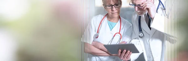 Dos médicos discutiendo sobre el informe médico en la tableta; panorámica — Foto de Stock