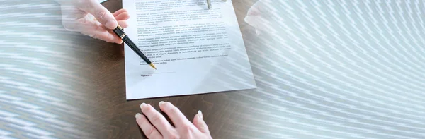 Realtor showing the signature place of a contract; panoramic ban