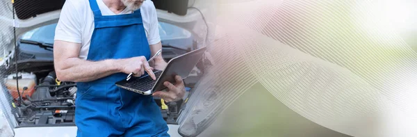 Mecânico usando laptop para verificar o motor do carro; bandeira panorâmica — Fotografia de Stock