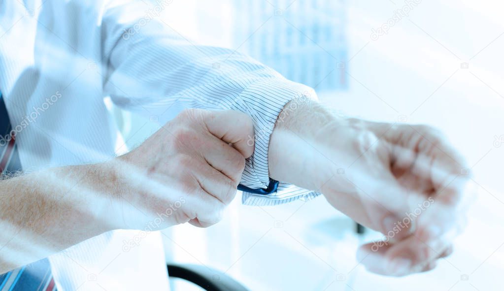 Businessman rolling up his sleeve; light effect