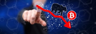 Dokunmatik ekranda bir bitcoin 'e dokunan adam ayı eğilimi kavramına parmağıyla dokunuyor