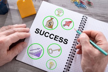 Masaya yerleştirilmiş bir not defterine başarı konsepti