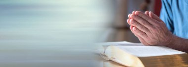 Elleri İncil 'in üzerinde dua eden adama yaklaş; panoramik pankart