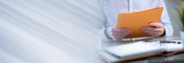 Ofiste bir dizin tutan işadamı; panoramik pankart