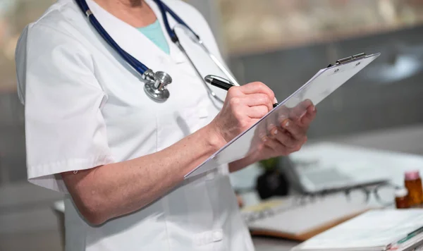 Vrouwelijke Arts Maakt Notities Klembord Het Medisch Kantoor — Stockfoto
