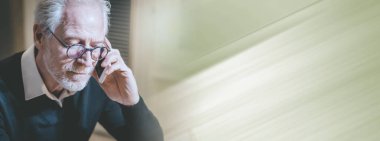 Evde cep telefonuyla konuşan üst düzey modern adamın portresi; panoramik pankart