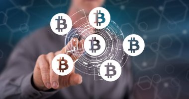 Bir adam dokunmatik ekranda bitcoin konseptine parmağıyla dokunuyor.