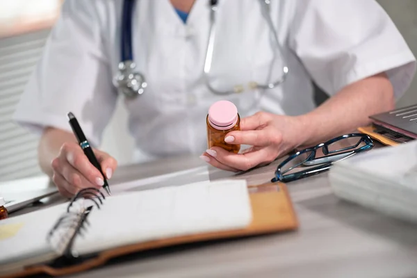 Ärztin Schaut Arztpraxis Auf Eine Flasche Pillen Und Schreibt Ein — Stockfoto