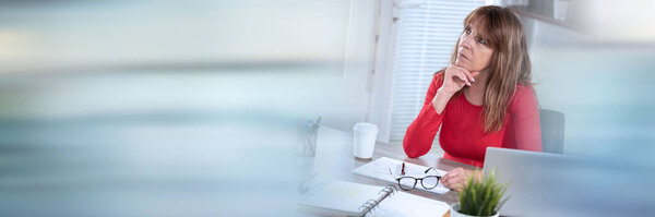 Портрет вдумчивой зрелой деловой женщины, смотрящей вверх; панорамный баннер