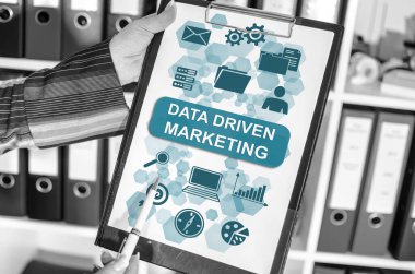 Elinde veri güdümlü pazarlama kavramı olan bir pano tutan kadın.