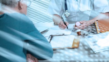 Tıbbi ofisindeki hastasına reçete yazan kadın doktor.