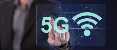 Bir adam dokunmatik ekranda 5G konseptine parmağıyla dokunuyor.