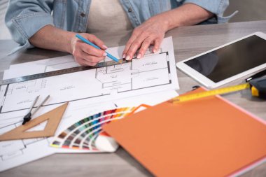 Yeni inşaat projesinin planı üzerinde çalışan kadın mimar