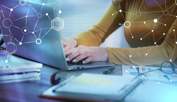 Businesswoman working on laptop in office; light effect