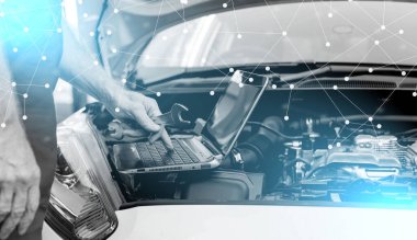 Araba tamircisi araba motorlarını kontrol etmek için dizüstü bilgisayar kullanıyor; ışık efekti