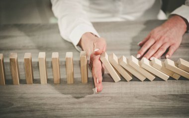 Domino etkisini durduran kadın eli. İş denetimi kavramı
