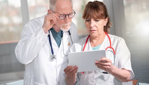 Zwei Gestandene Ärzte Diskutieren Über Arztreport Auf Digitalem Tablet — Stockfoto